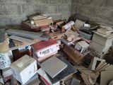 a pile of boxes and books in the corner of a room
