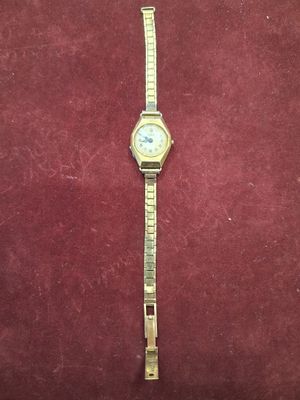 une image d'une montre en or posée sur un fond de velours rouge