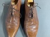pair of men ' s brown leather shoes with laces on them