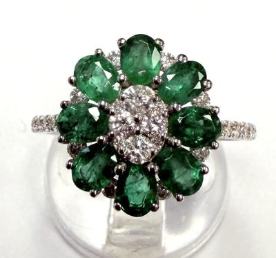 un gros plan d'une bague ornée de pierres vertes et blanches