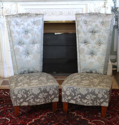 une paire de fauteuils rembourrés devant une cheminée dans un salon
