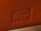 someone is writing on a piece of brown leather with a pen