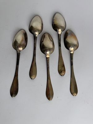six spoons are lined up in a row on a white surface