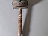 a small wooden mallet with a turquoise stone on it