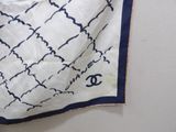 a white and blue scarf hanging on a wall