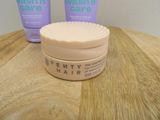 two bottles of hair care sitting on a wooden table