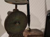 a small clock on a table next to a pen and inkwell
