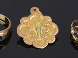 three gold rings and a ring with an image of jesus on it