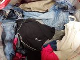 a pile of clothes in a suitcase with a hat on top