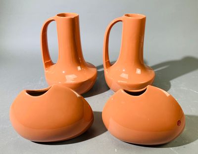 trois vases orange posés les uns à côté des autres sur une table