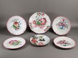 plusieurs assiettes ornées de fleurs et d'oiseaux sur un fond gris