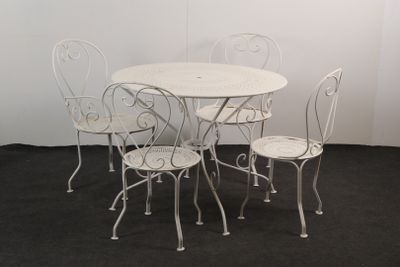 une table blanche et quatre chaises dans une pièce