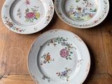 three plates on a wooden table with flowers on them