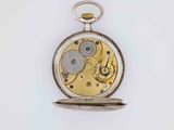 a silver and gold pocket watch on a white surface