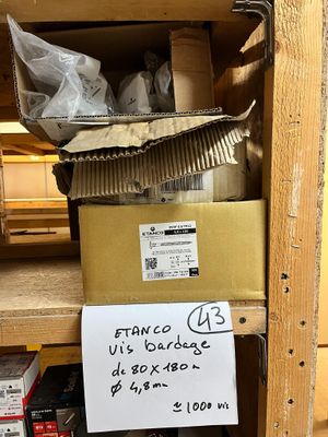 une pancarte posée sur une étagère dans une pièce où se trouvent des cartons et d'autres objets