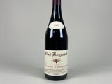 une bouteille de vin rouge posée sur une table blanche