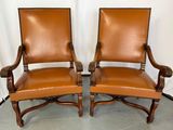 une paire de fauteuils en cuir avec des accoudoirs en bois