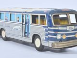 a blue and white bus that is on a white surface