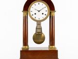 une image représentant une horloge en bois surmontée d'un pendule