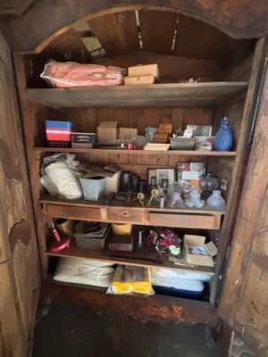 a wooden shelf with many items on it in a room
