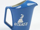 a close up of a blue pitcher with a gitanes logo on it