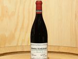 a bottle of wine sitting on top of a barrel