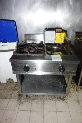 une cuisinière sale dans une cuisine sale, à côté d'une poubelle