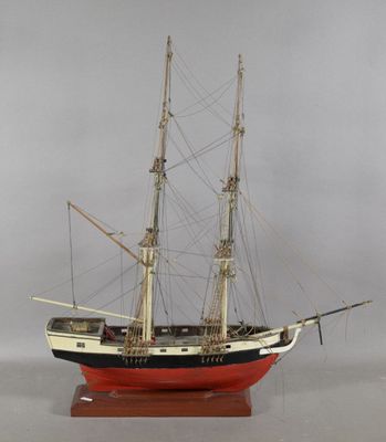 une petite maquette de bateau posée sur un socle en bois