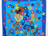 un gros plan sur une écharpe bleue ornée de fleurs et du mot « love »