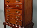 une vieille commode en bois posée sur un socle, devant un fond blanc