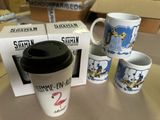 four coffee mugs sitting on a table next to a box of boxes