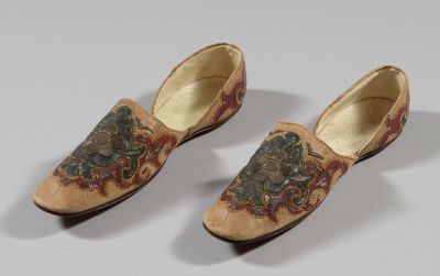 deux paires de chaussures ornées de motifs floraux, posées sur une surface blanche