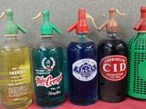 de nombreuses bouteilles de différentes couleurs alignées sur une table