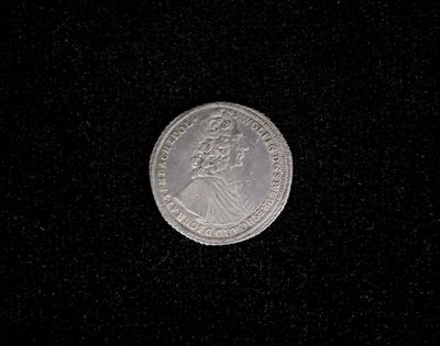 a close up of a silver coin on a black surface