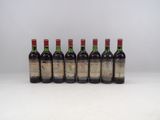 six bouteilles de vin alignées sur une surface blanche
