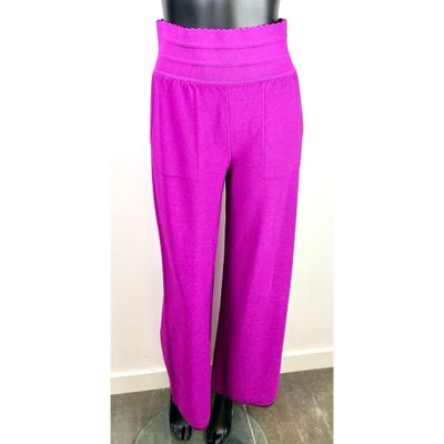 un pantalon violet sur un mannequin se tient devant un mur blanc