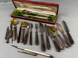 many different types of knives and spoons in a case
