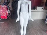 un mannequin dans un magasin de vêtements, avec des vêtements exposés