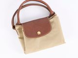 a small tan and brown purse with a brown handle