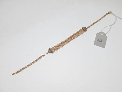 un bracelet en chaîne d'or auquel est attachée une plaque