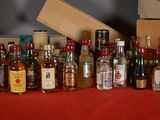 many bottles of alcohol lined up on a red table