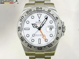 une montre Rolex avec un cadran blanc et une trotteuse orange