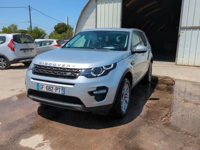 La Land Rover argentée est garée devant un garage.
