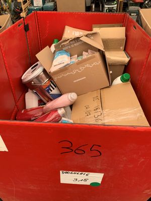 une poubelle rouge remplie de cartons et d'autres objets