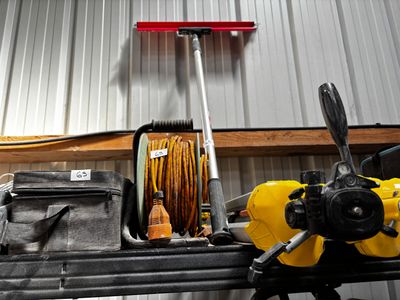un tuyau jaune posé sur une table, à côté d'un sac à outils