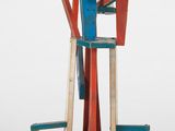 statue d'un homme debout au sommet d'une estrade rouge, blanche et bleue