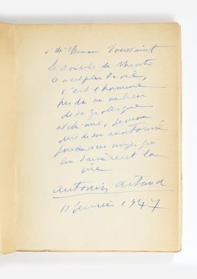 un livre ouvert, sur lequel figure un poème écrit à la main, posé sur une table