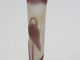 a glass vase with a bird on it sitting on a table