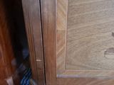 a close up of a wooden cabinet with a cat on top of it