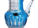 a blue glass pitcher with a handle on a stand